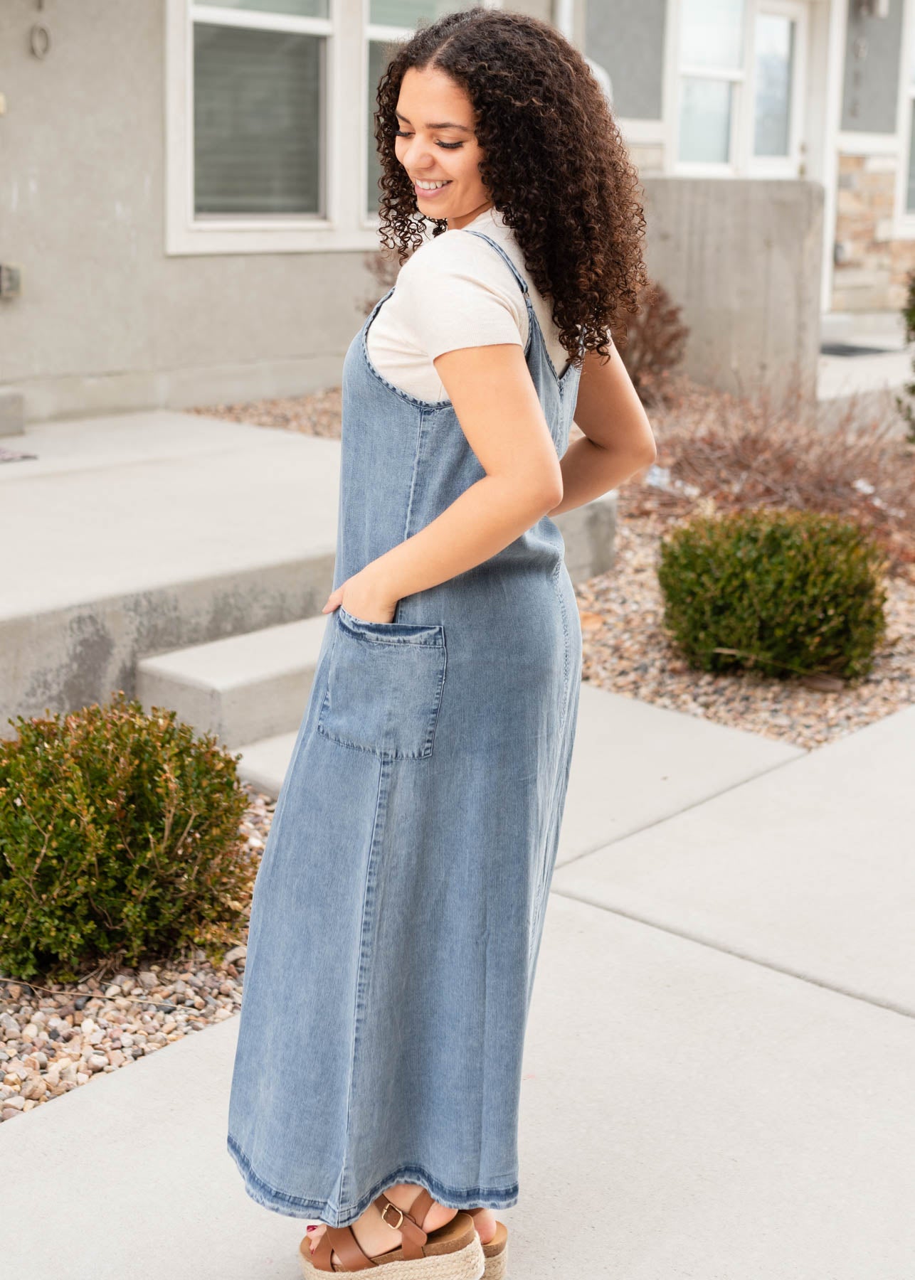 Side view of the denim blue overall dress