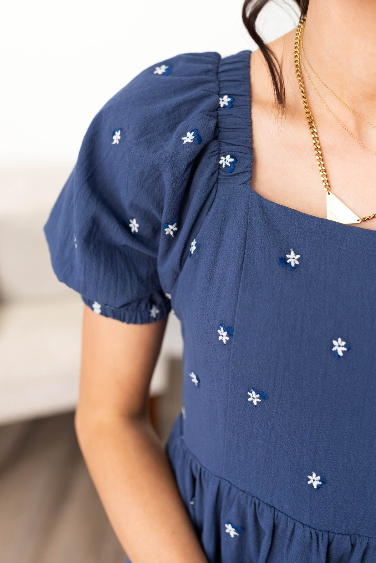 Close up of the sleeve and fabric on the navy embroidered floral dress