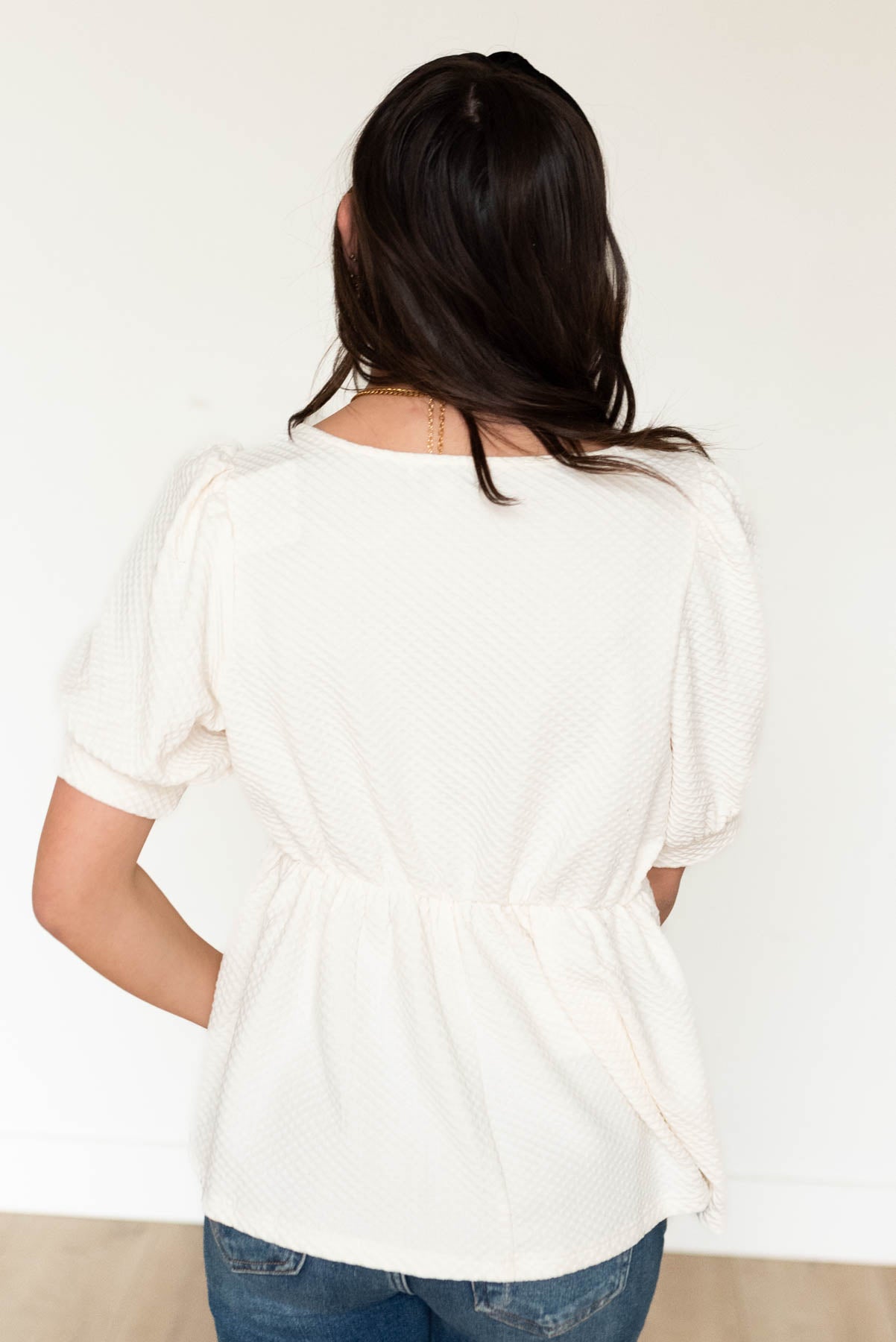 Back view of the cream ruffle top