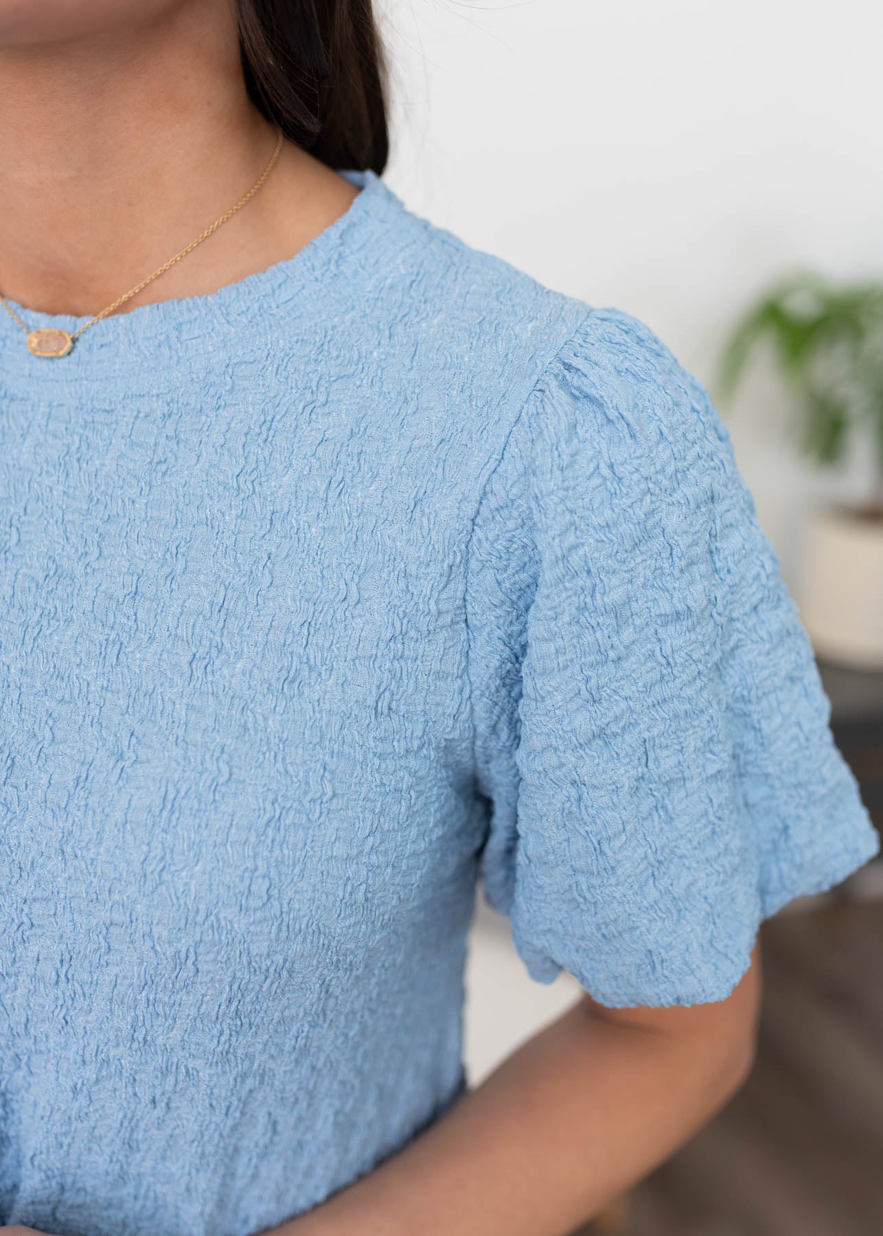 Close up of the sleeve and fabric of the blue textured top