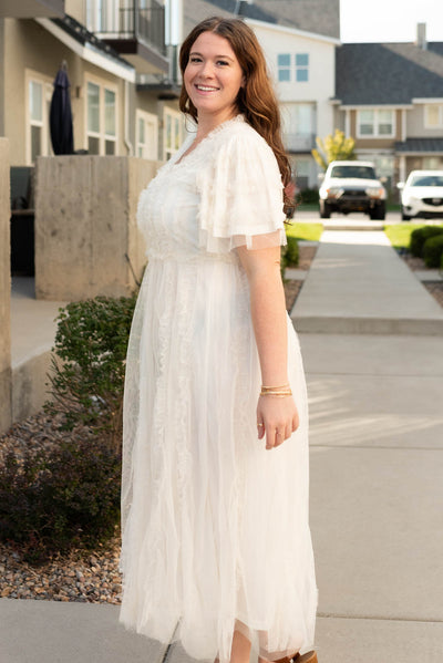 Side view of the cream sheer ruffle dress in plus size