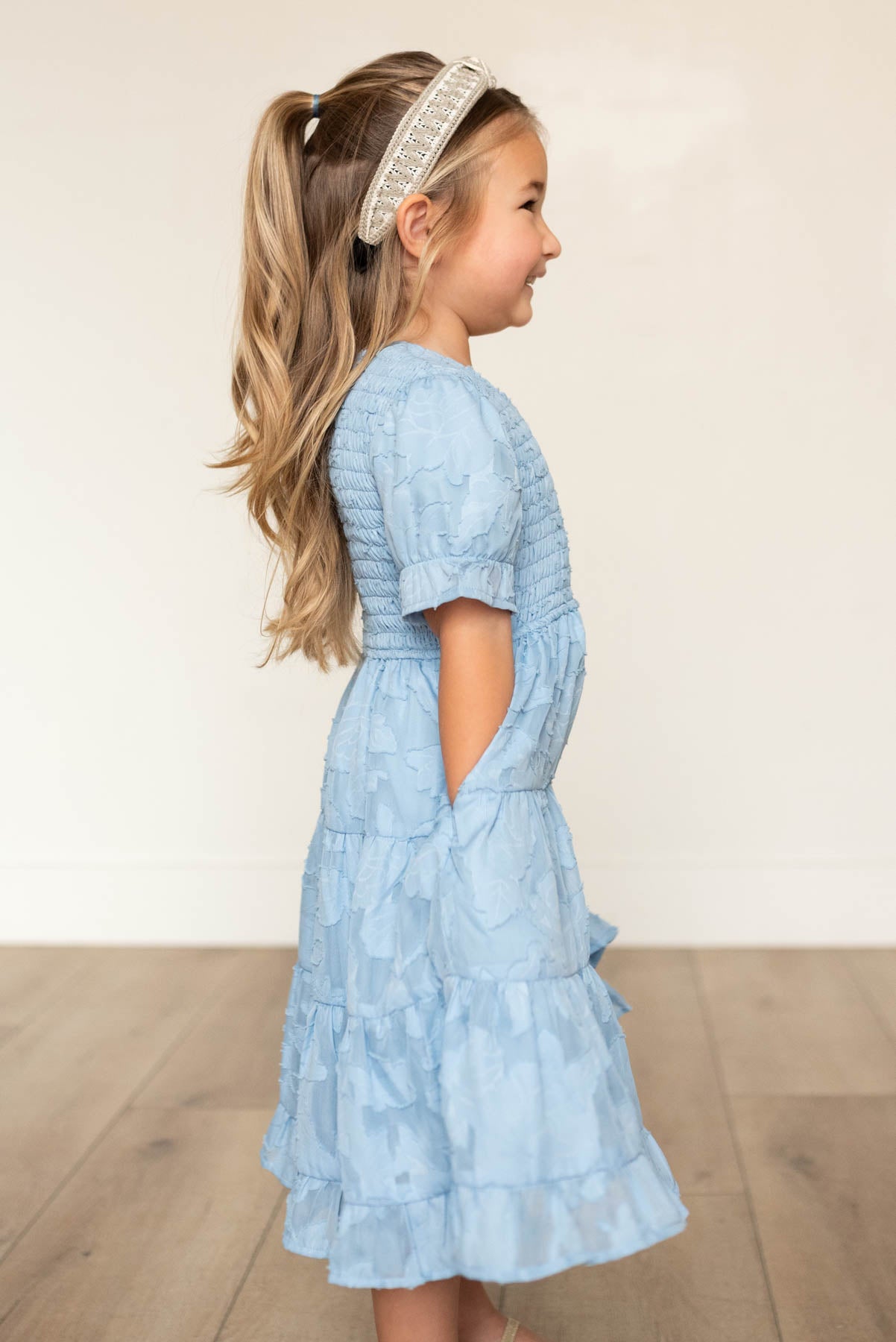 Side view of the blue floral tiered little girl dress with pockets