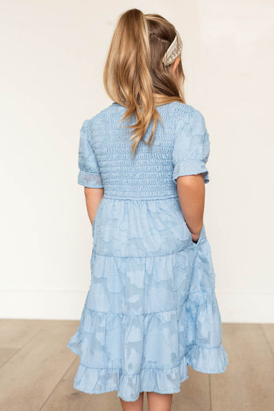 Back view of the blue floral tiered little girl dress with pockets