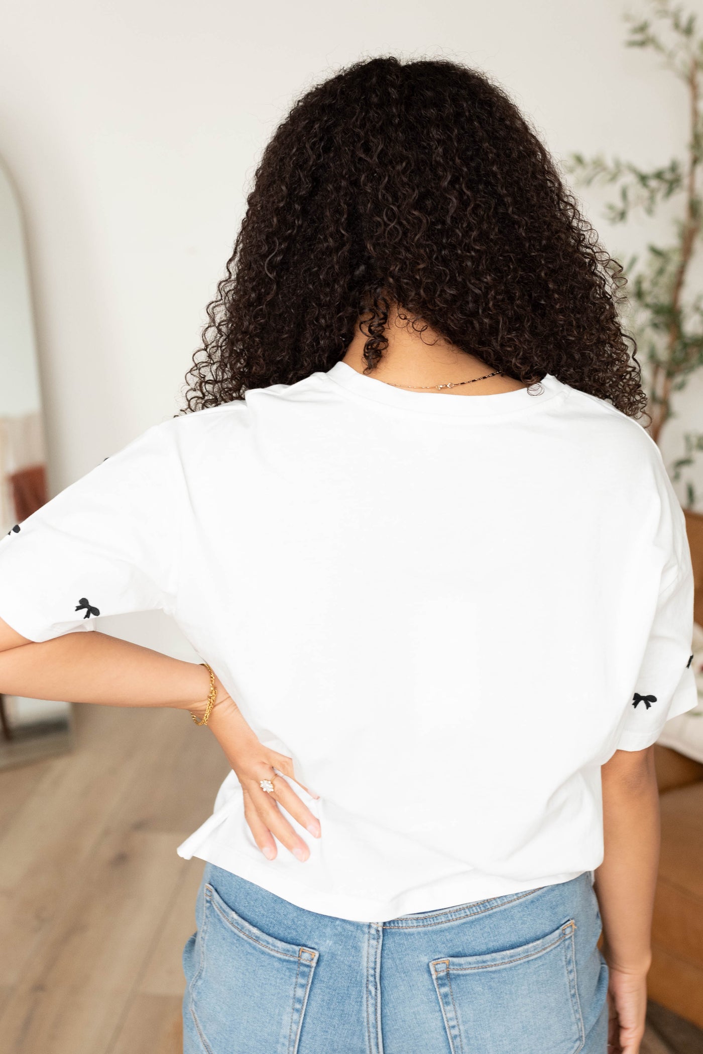 Back view of the white tee black embroidered bow top