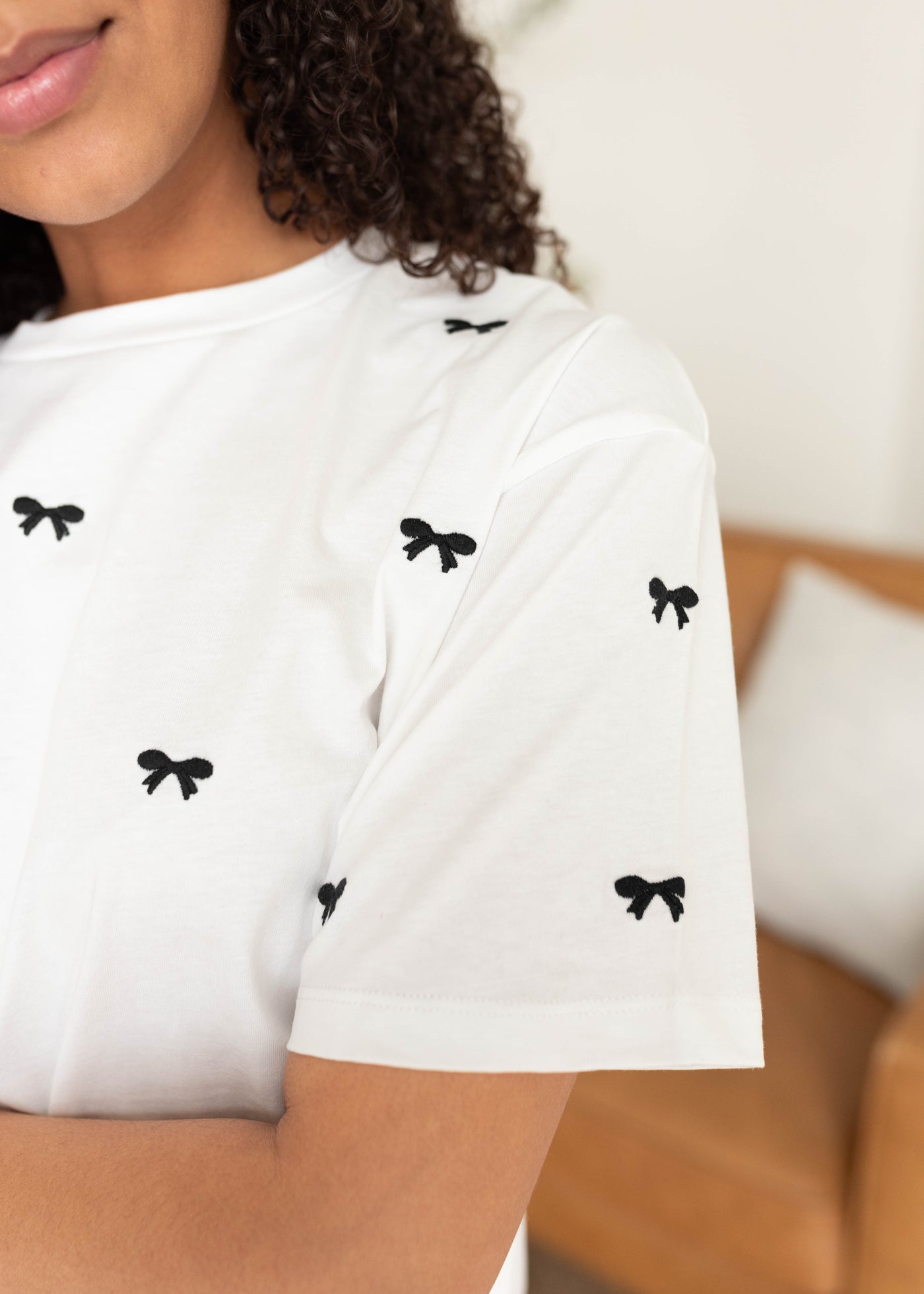 Close up of the white tee with black embroidered bow top