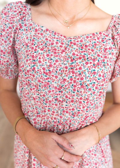 Close up of the neckline and fabric on the red floral puff sleeve dress