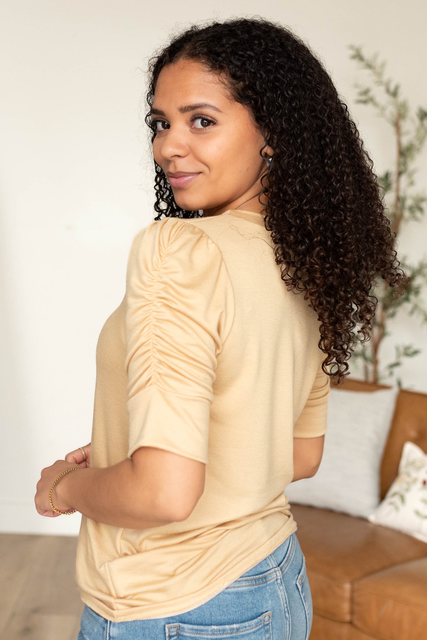 Side view of the taupe ruffle sleeve top with gathering on sleeve