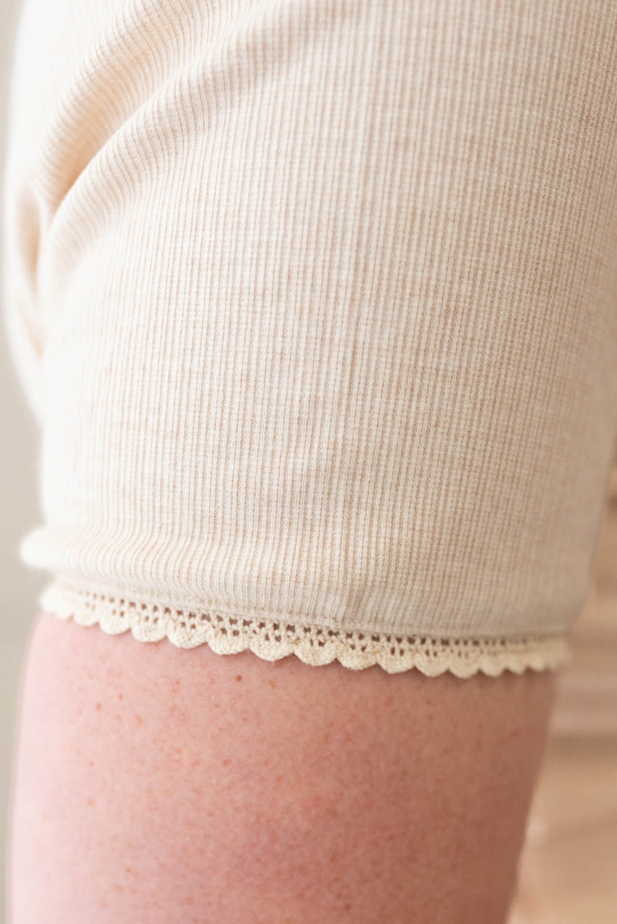 Close up of the lace trim on the oatmeal lace trim ribbed top