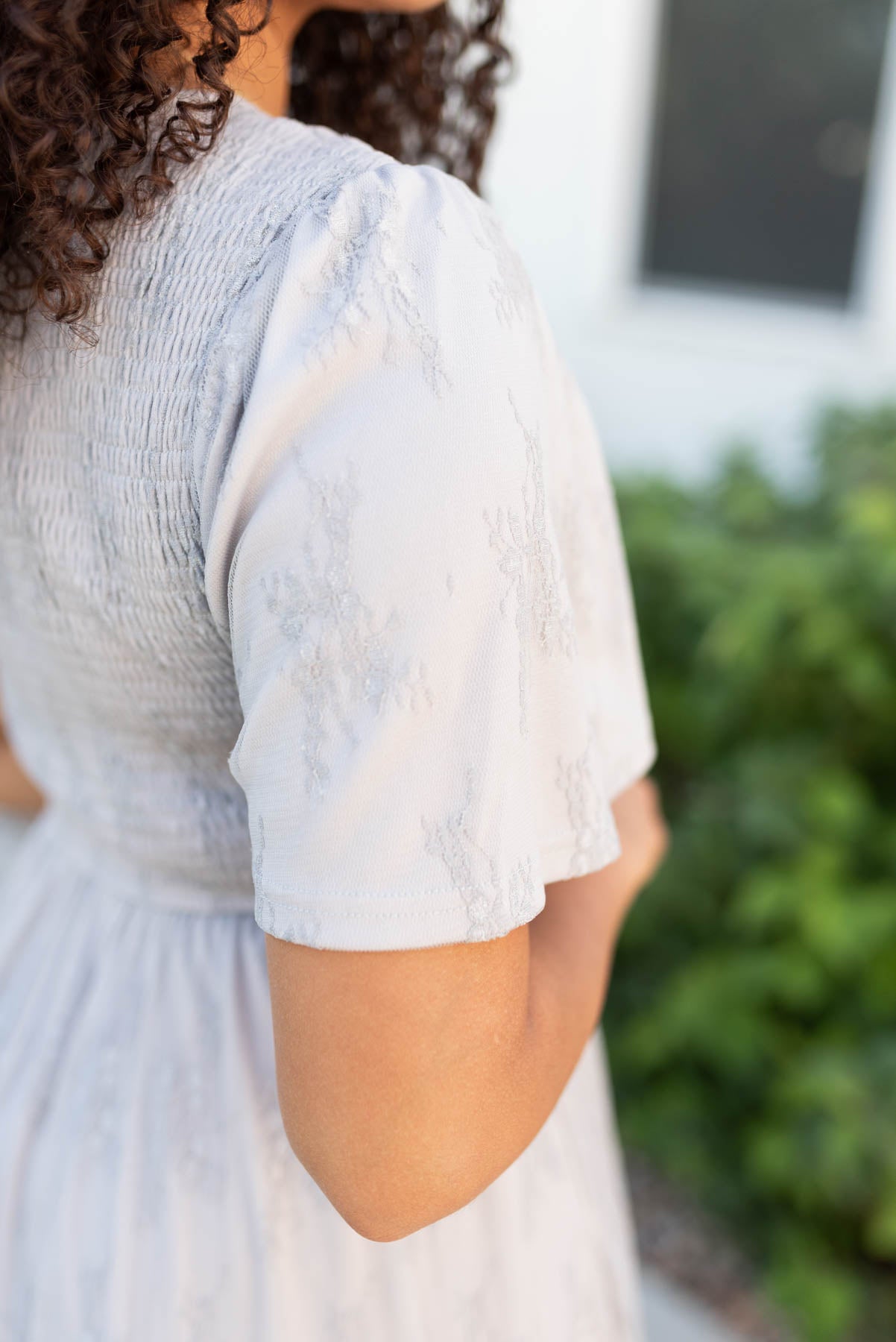 Close up of the sleeve on the grey floral lace dress