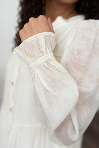 Close up of the sleeve and fabric on the ivory button down dress