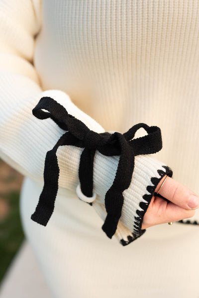 Close up of the black tie bows on the plus size cream knit sweater