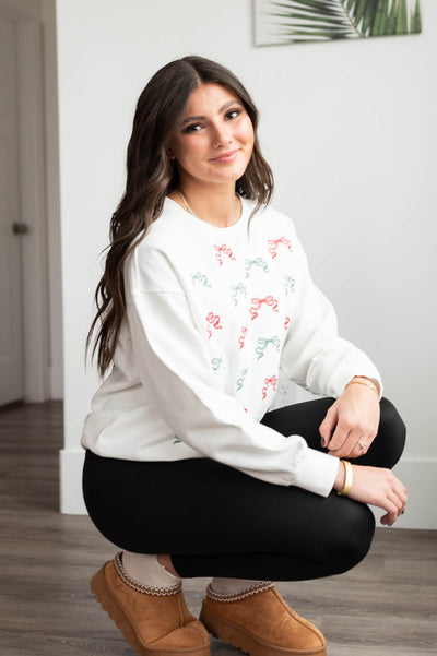 Red and green bows onthe white Christmas bow sweater