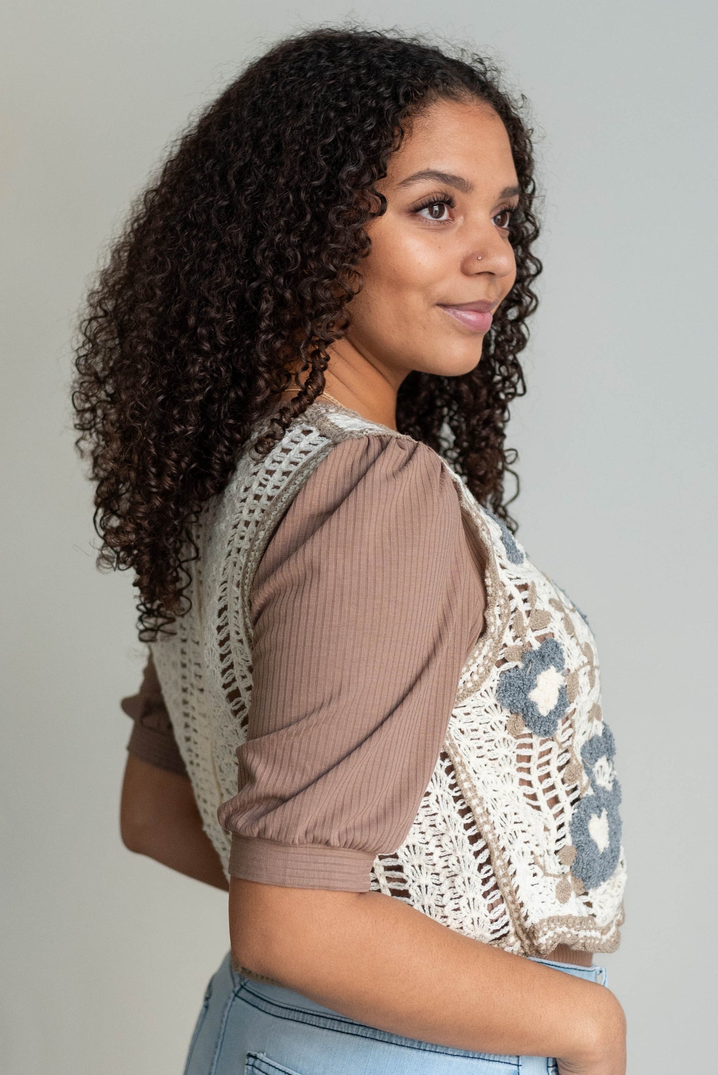 Side view of the cream floral crochet vest