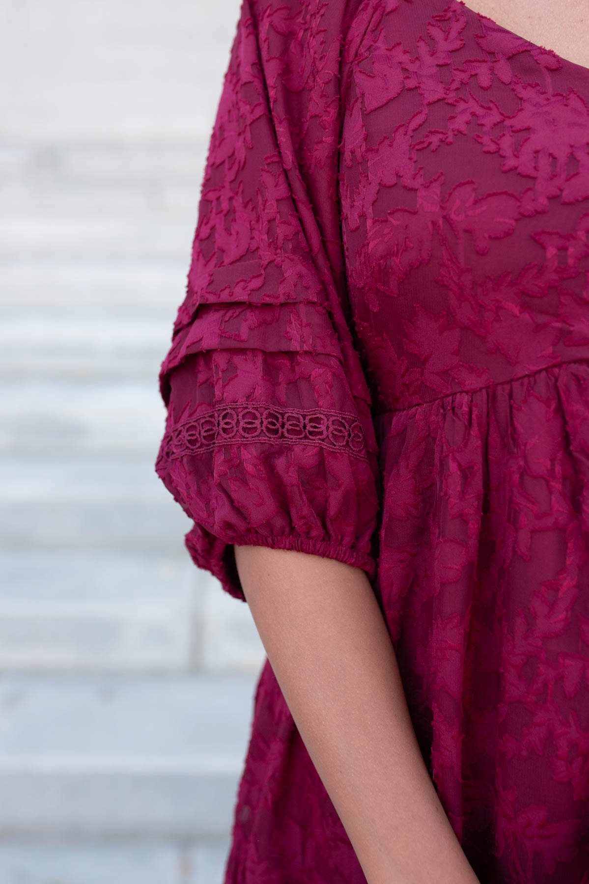 Close up of the sleeve and lace detail on the red floral pattern dress