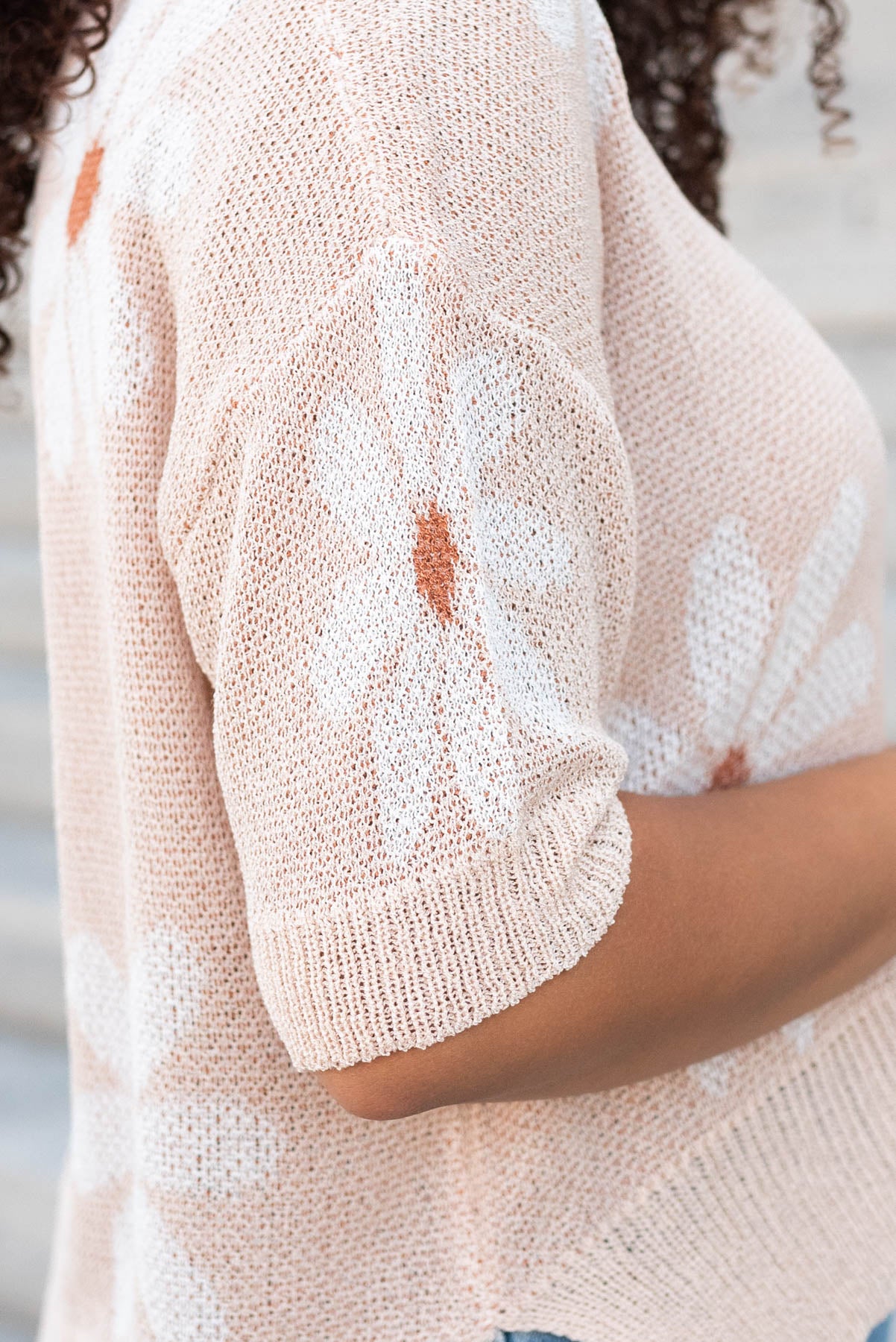 Close up of the sleeve on the taupe floral knit top