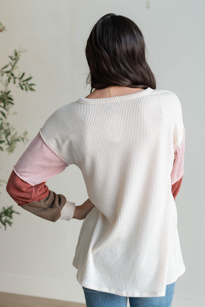 Back view of the cream color block long sleeve top