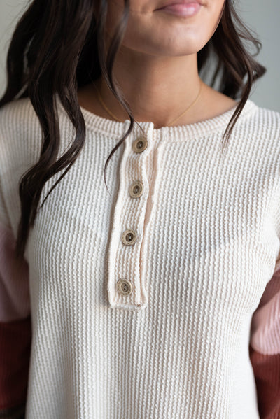 Close up of the fabrc on the cream color block long sleeve top