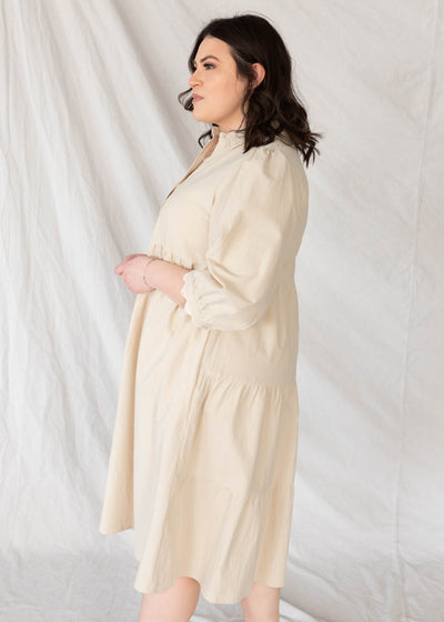 Side view of the plus size beige btton down dress