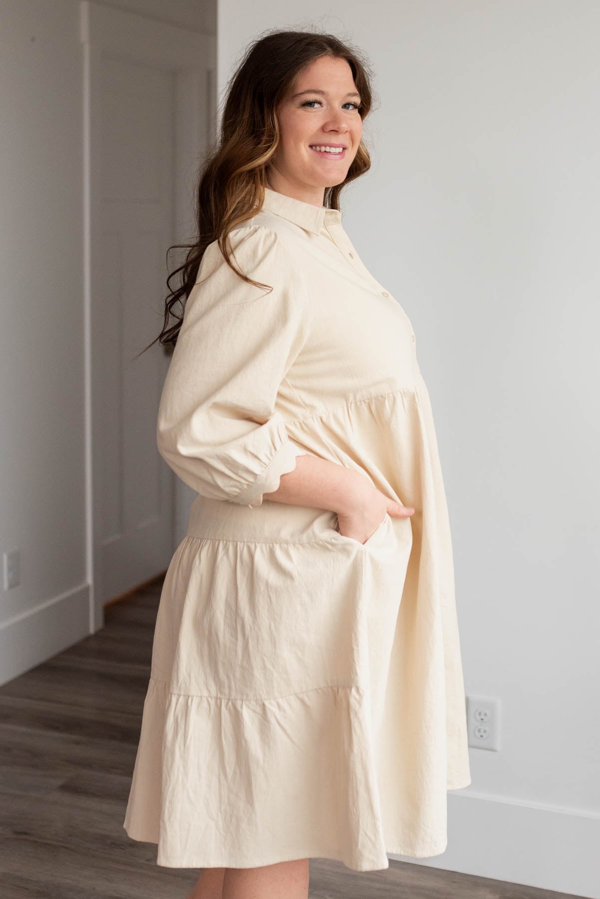 Side view of the beige button down dress in plus size with pockets