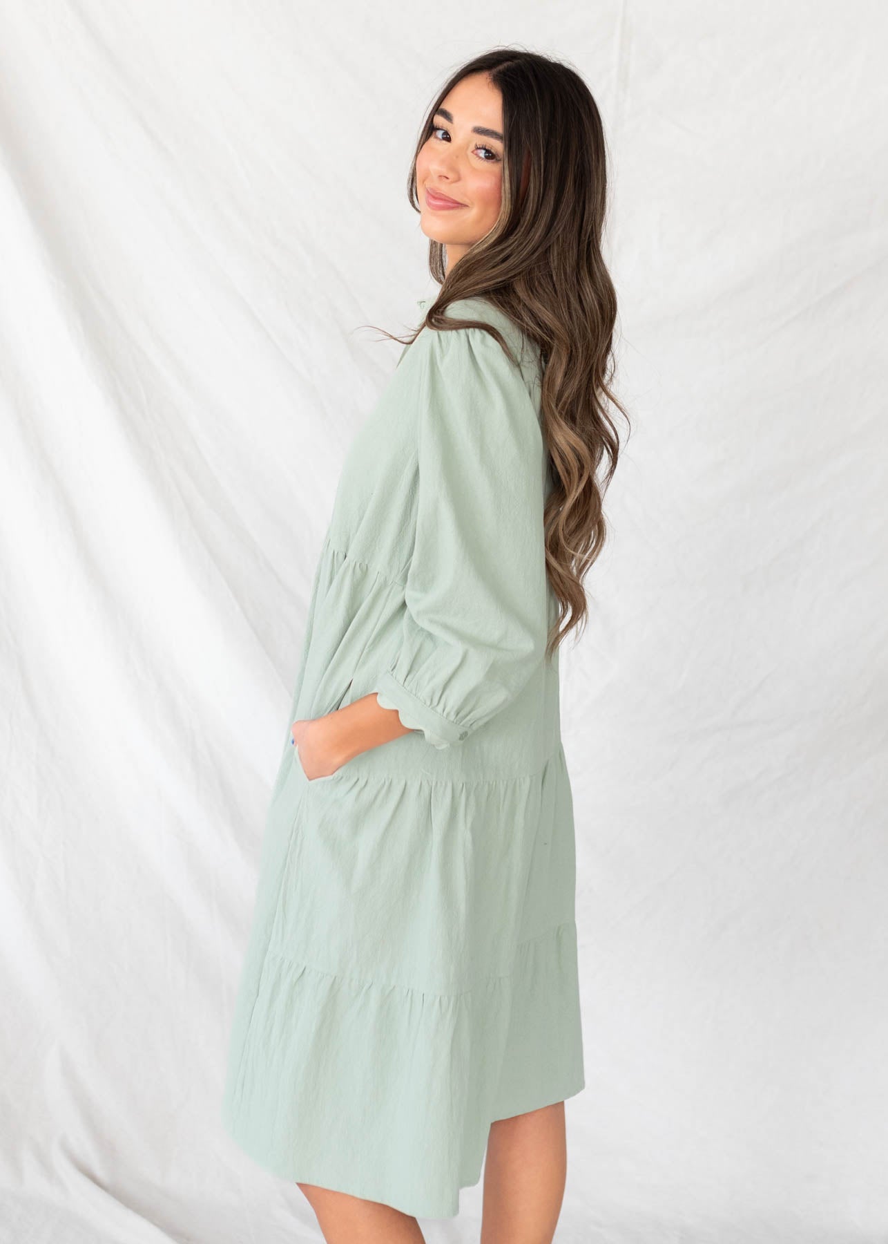 Side view of the sage button downdress with pockets