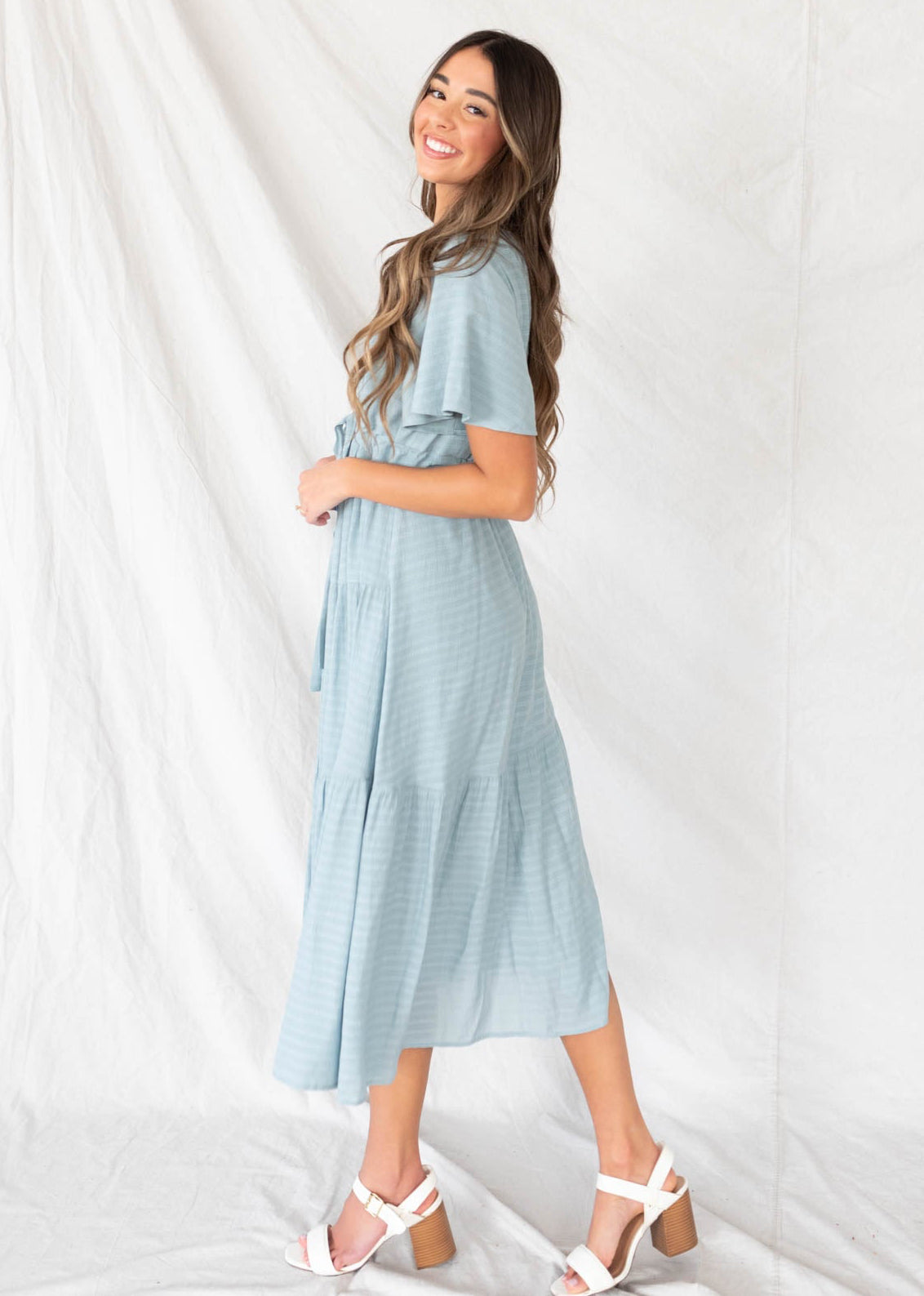 Side view of the dusty blue textured tiered dress with textured fabric