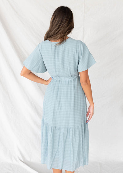 Back view of the dusty blue textured tiered dress