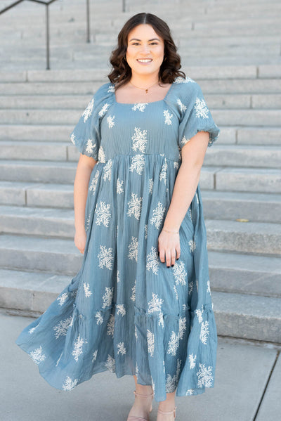 Front view of the plus size dusty blue embroidered dress with a square neck and white flowers