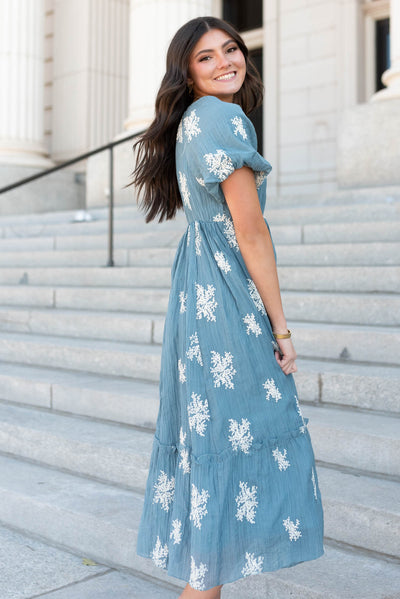 Side view of the dusty blue embroidered dress