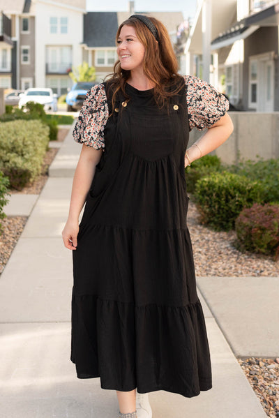 Front view of the plus size black overall dress