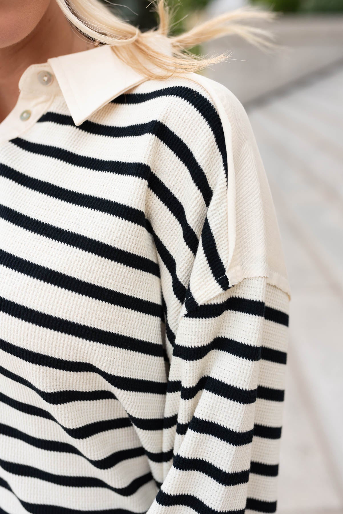 Close up of the fabric on the black stripe pullover shirt with button placket