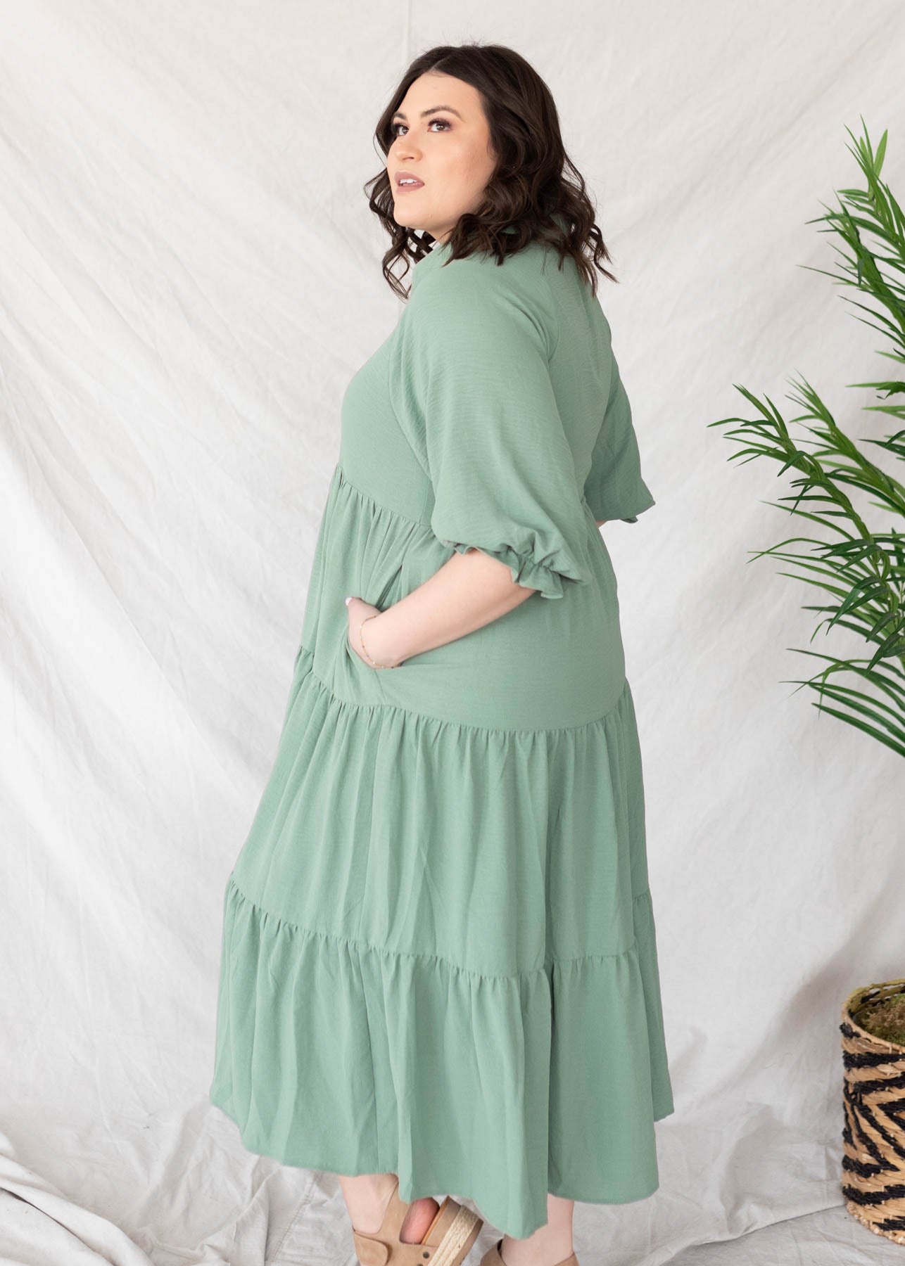 Side view of the plus size green collared tiered dress with pockets