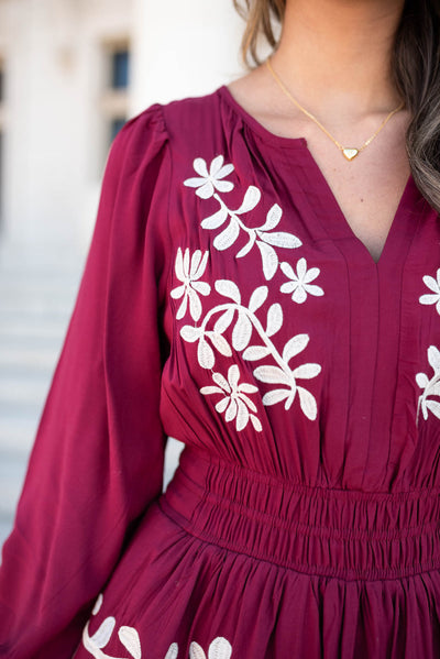 Close up of the ivory embroidery on the  wine floral embroidered dress