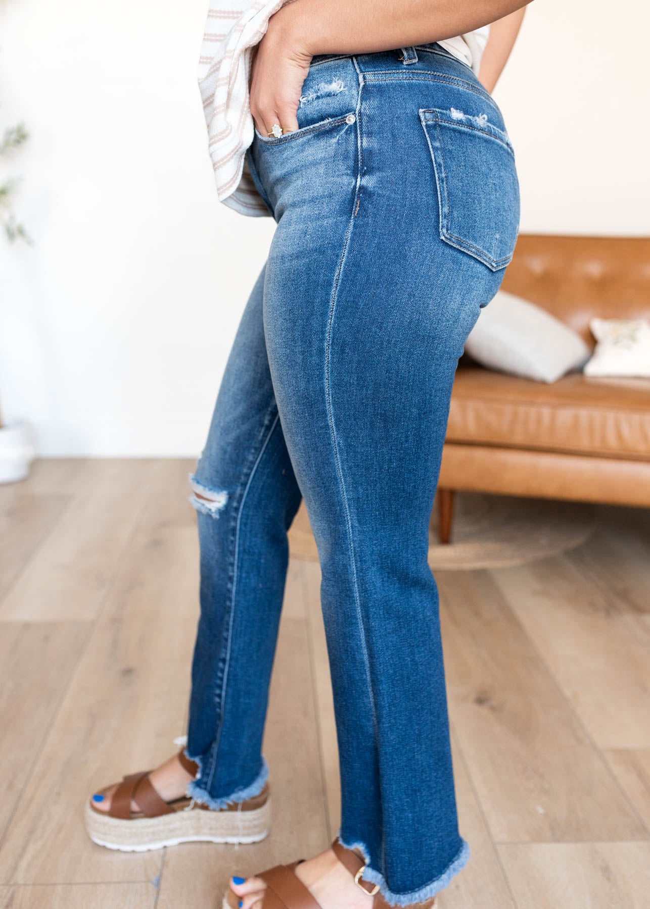 Side view of the distreed dark denim jeans