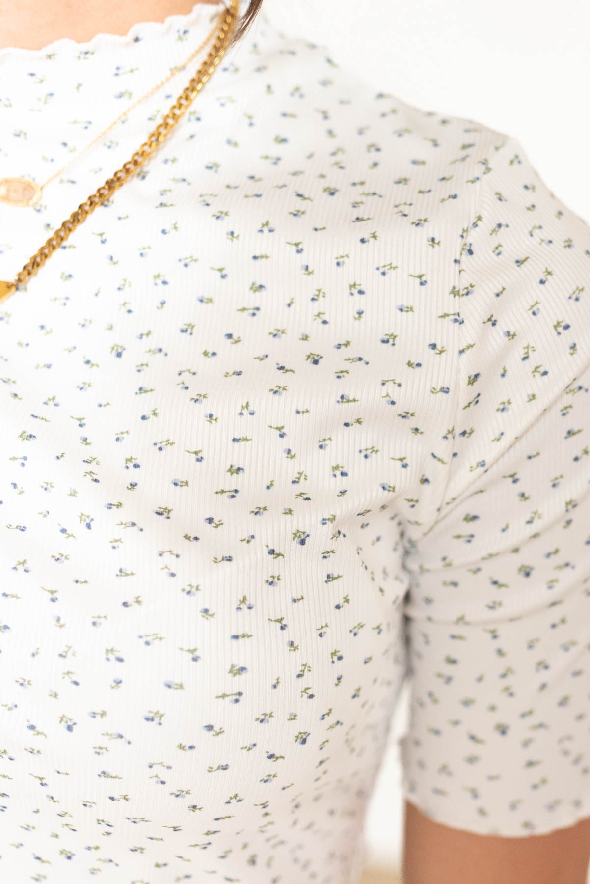 Close up of the floral pattern on the ivory floral ruffle top