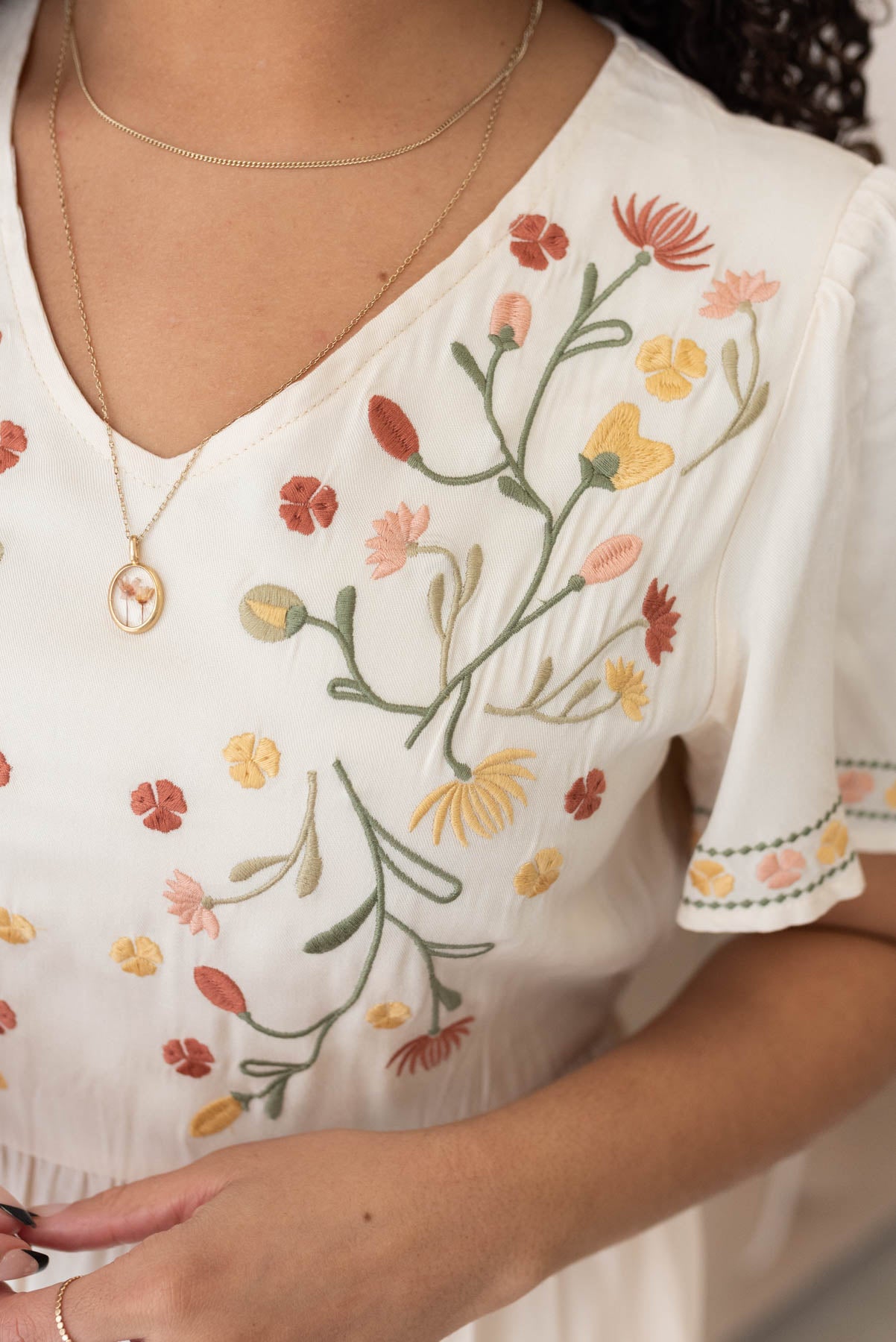 Close up of the embroidery on the bodice of the ivory embroidered tiered dress