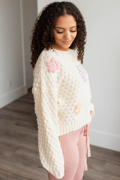 Side view of the cream knit flower sweater