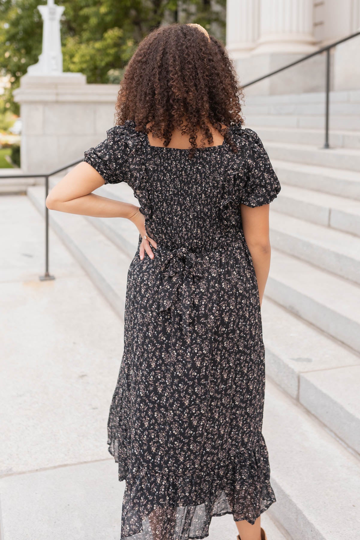 Back view of the black floral dress with ruffle on the hem