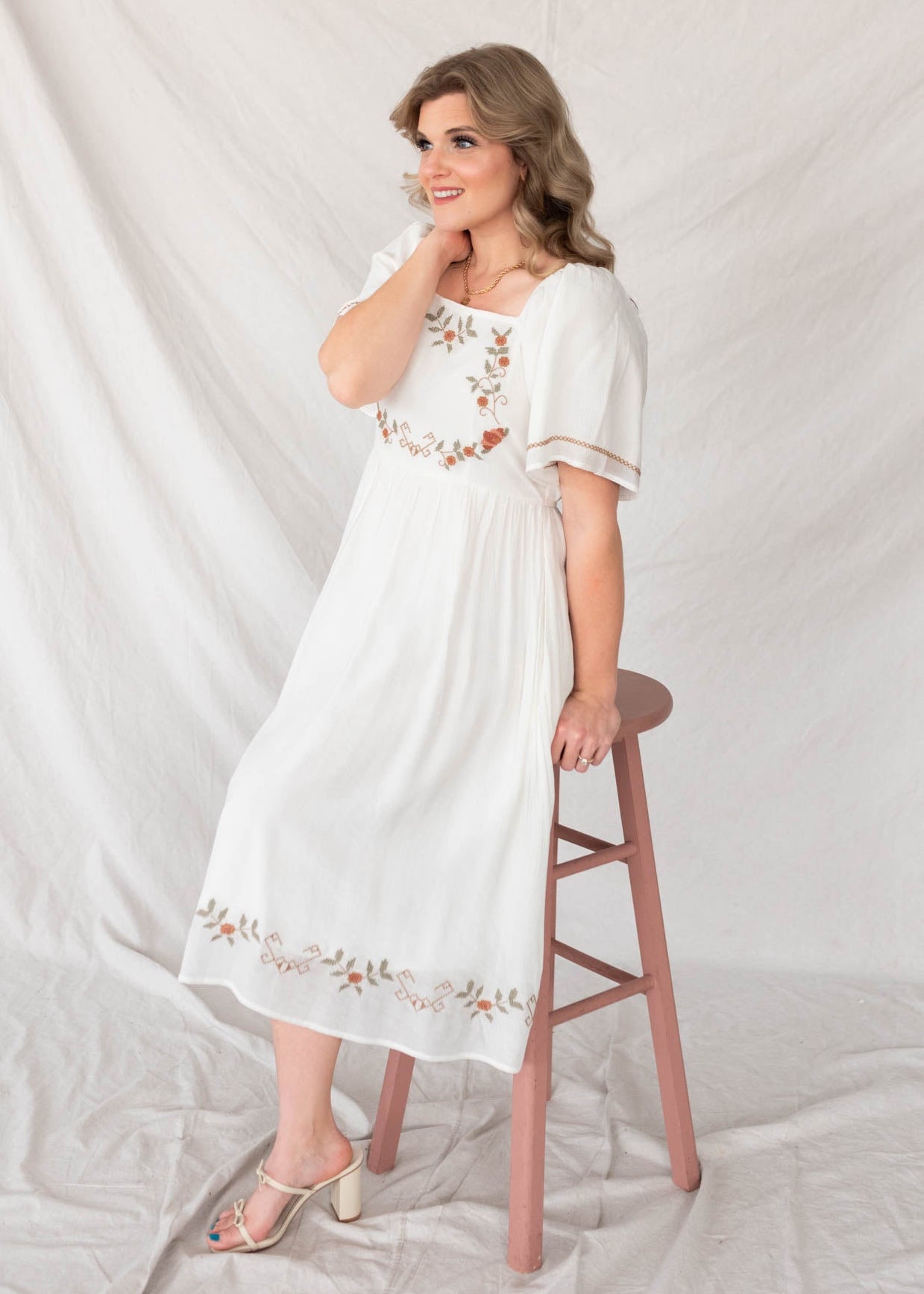 White embroidered dress with embrodery on the hem and cuffs of the sleeves