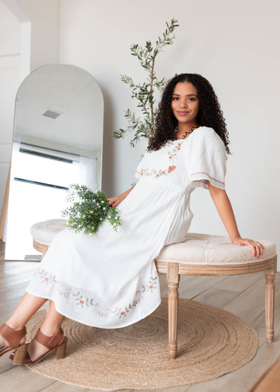 White embrodeted dress with embroidery on the sleeves and hem