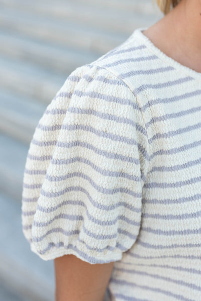 Close up of the puff sleeve on a dusty purple stripe top