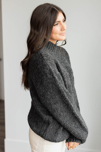 Side view of the black knit sweater