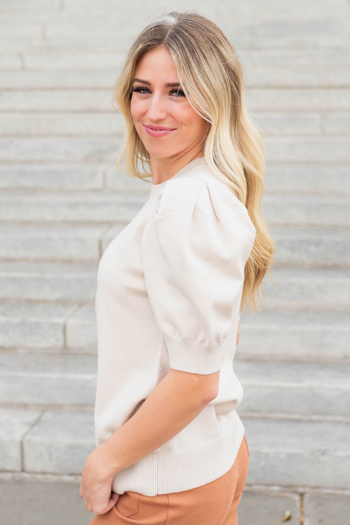 Side view of the beige puff sleeve sweater top