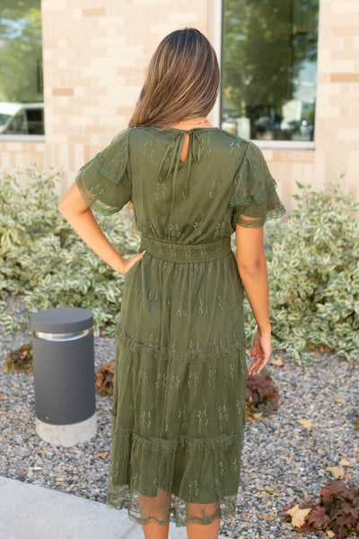 Back view of the dark green floral lace dress that ties at the neck