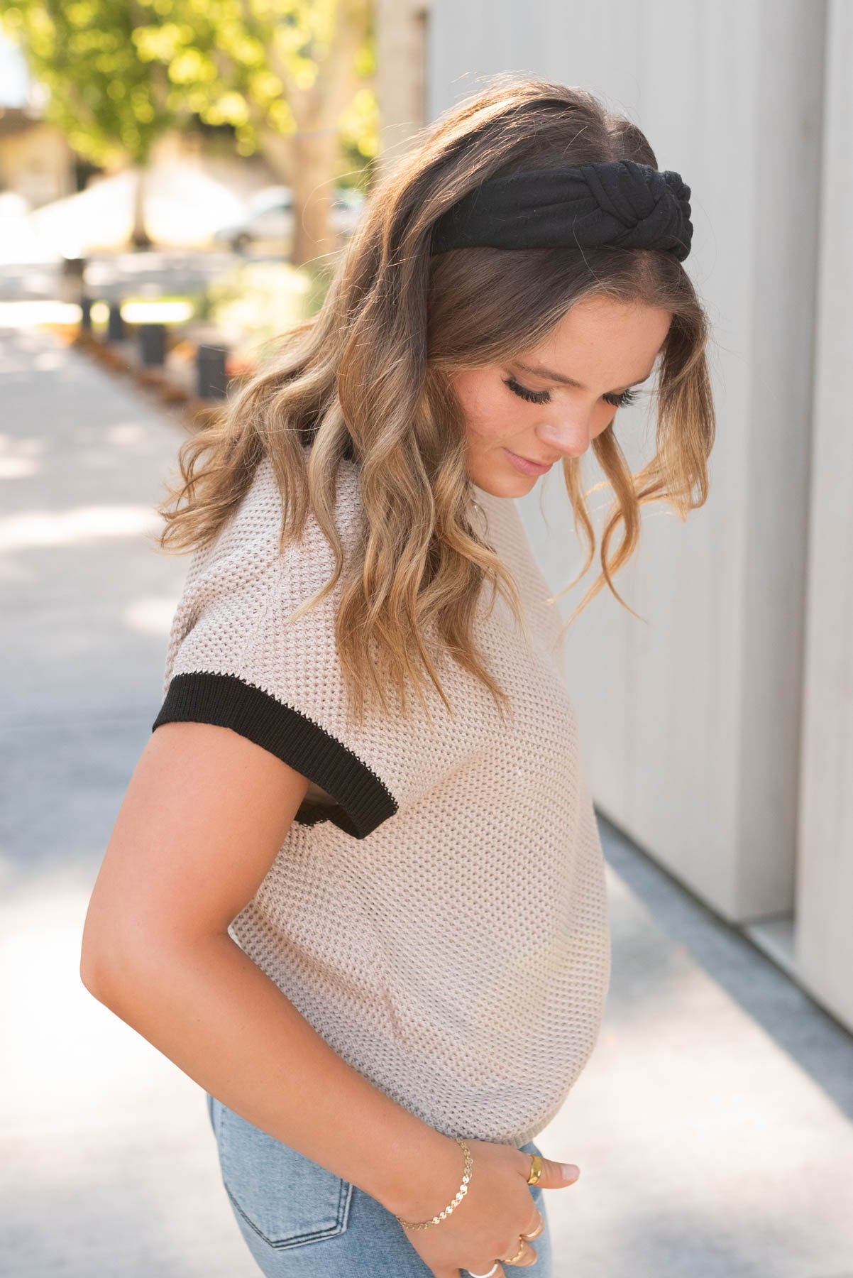 Side view of the beige black trim sweater