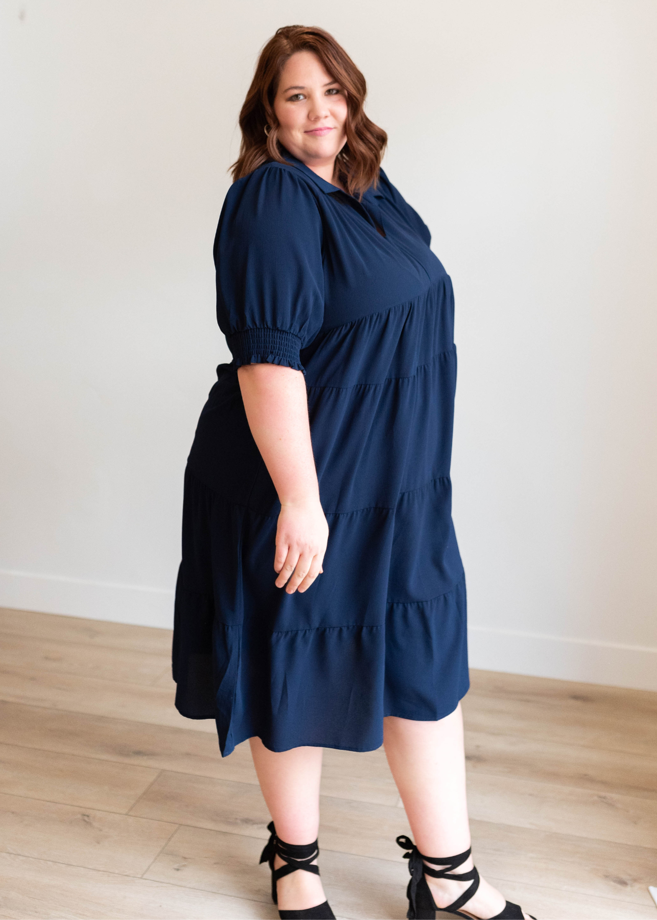 Side view of the plus size navy collared tiered dress