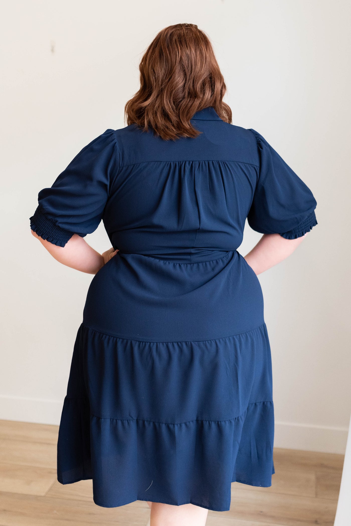 Back view of the navy collared tiered dress