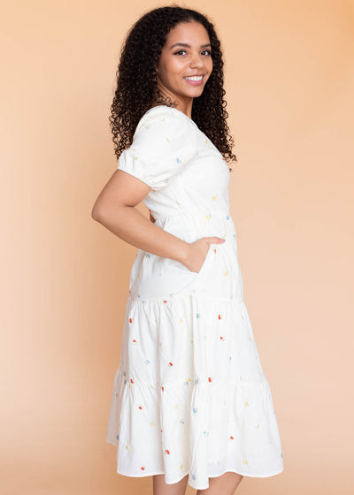 Side view of the cream floral embroidered dress with pockets