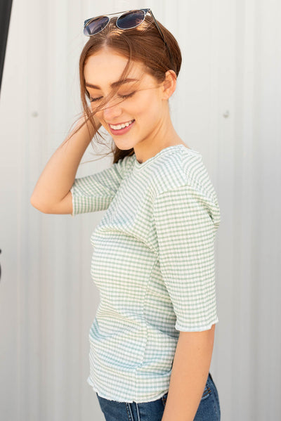 Side view of the sage plaid top