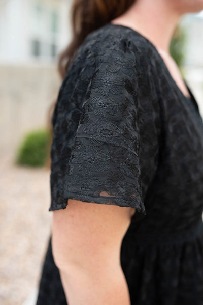 Close up of the sleeve and fabric on the black floral lace dress