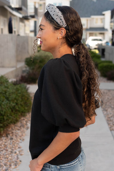 Side view of the black puff sleeve pullover